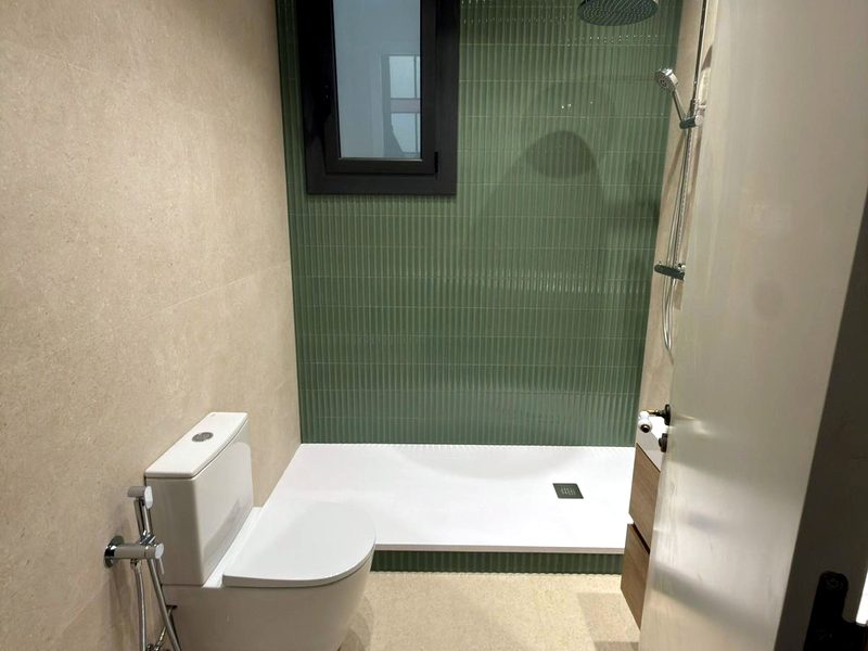 Baño con azulejo verde y carpintería oscura — Barcelona